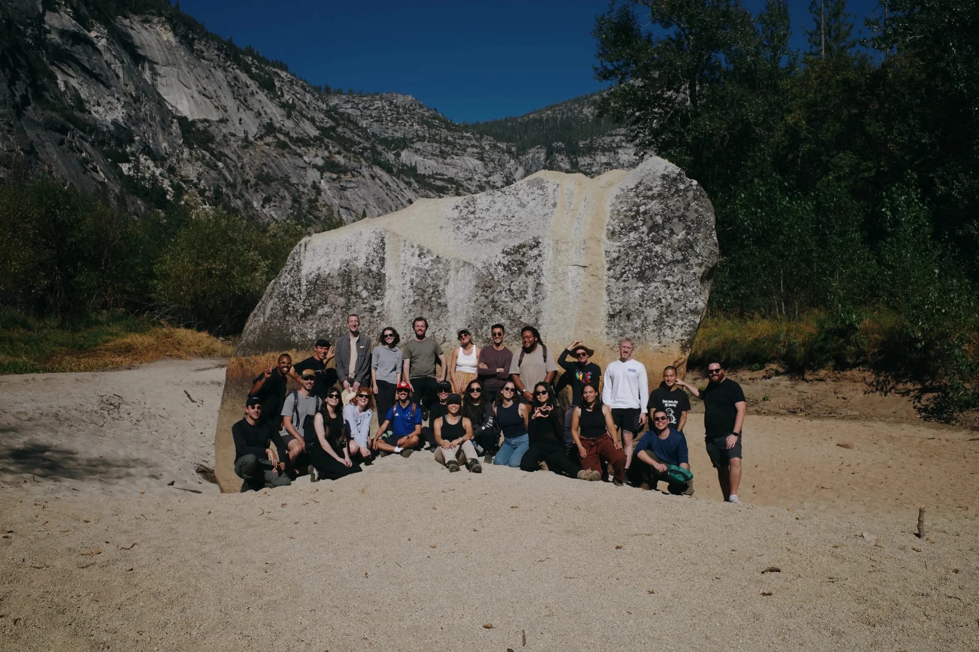 XXIX team gathered outdoors in front of a large boulder